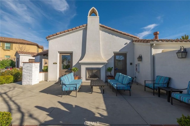 view of patio with an outdoor living space with a fireplace