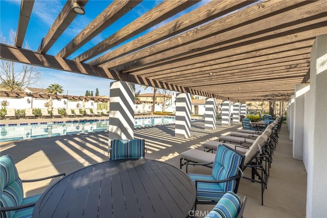 view of patio / terrace featuring outdoor dining space, a community pool, and a pergola