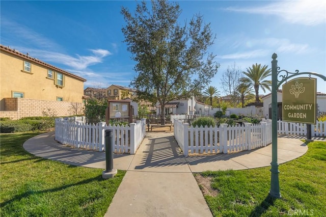 exterior space with a residential view, fence, and a lawn