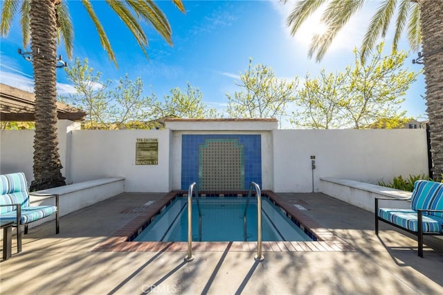 view of pool with a swimming pool, a patio area, and fence