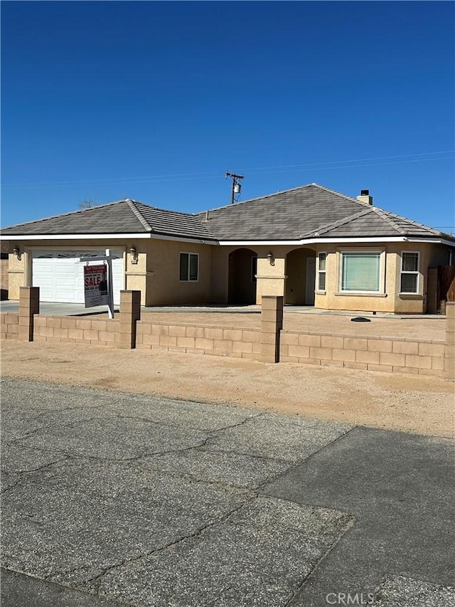 ranch-style house featuring a fenced front yard and stucco siding