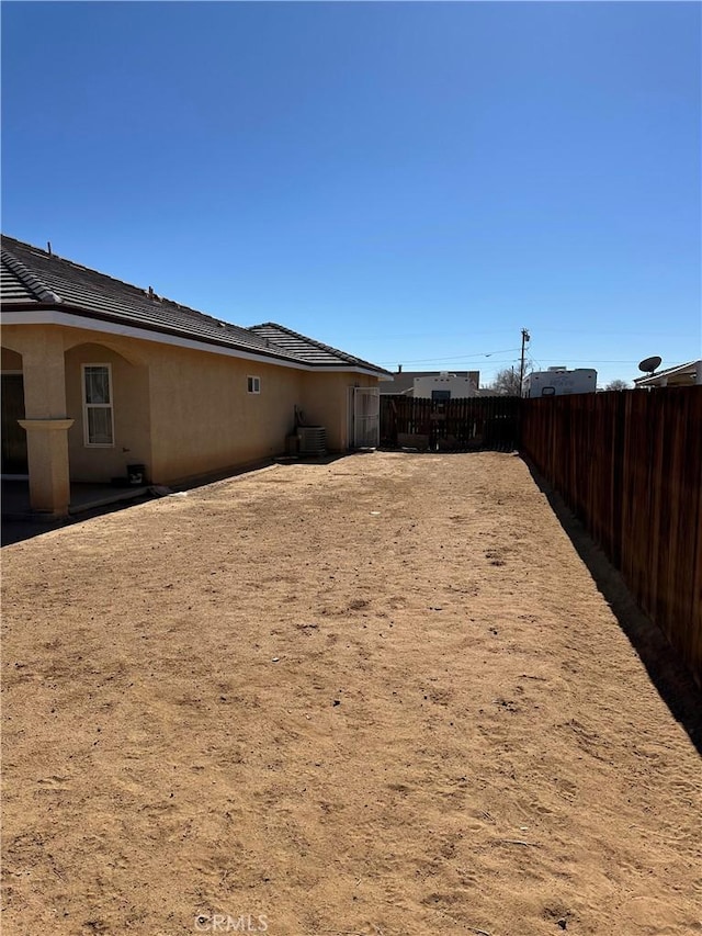 view of yard with central air condition unit and fence