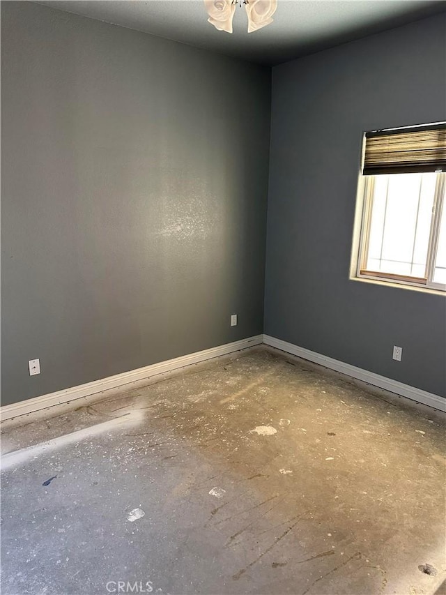 spare room with baseboards