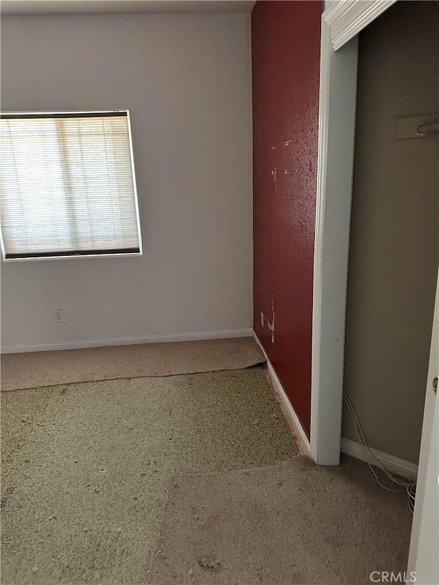 unfurnished room with baseboards