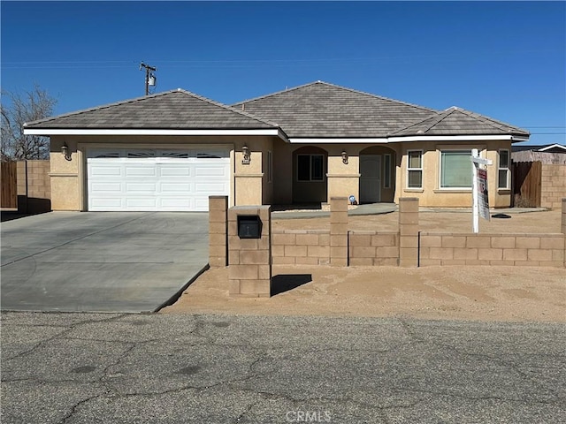 single story home with concrete driveway, an attached garage, fence, and stucco siding