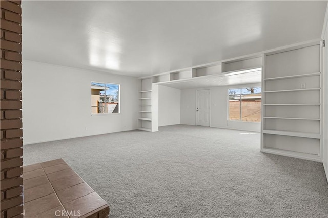 unfurnished living room featuring carpet floors and built in features