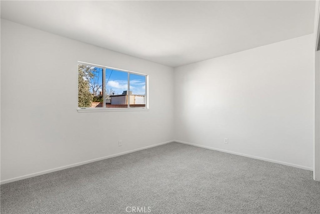 spare room with carpet and baseboards