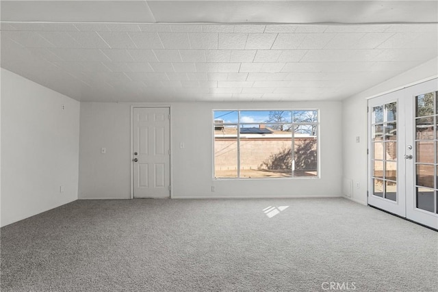 unfurnished living room with carpet floors and french doors