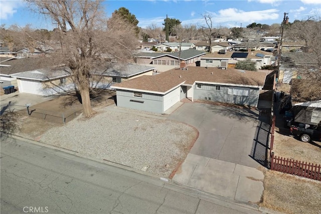 view of front facade featuring driveway, fence, and a residential view