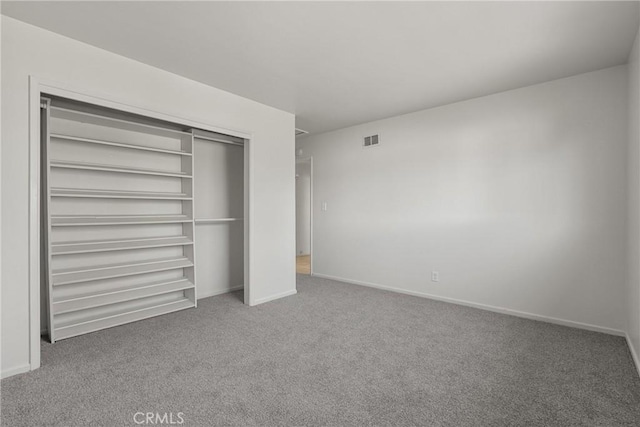 unfurnished bedroom featuring a closet, carpet, visible vents, and baseboards