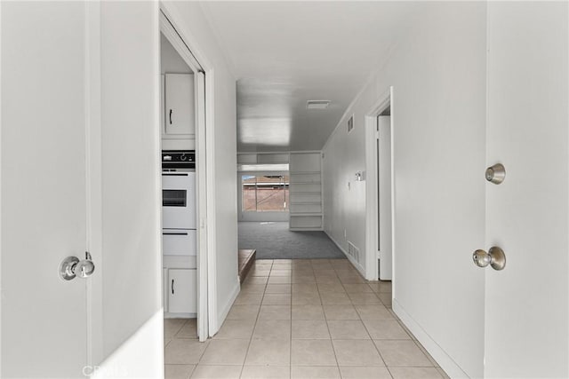 hall with visible vents and light tile patterned floors