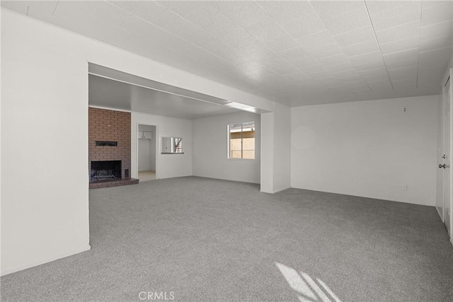 unfurnished living room featuring carpet and a fireplace