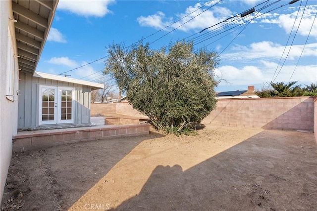 view of yard featuring a fenced backyard and french doors