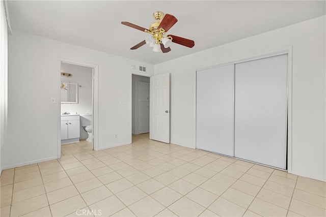 unfurnished bedroom featuring light tile patterned floors, visible vents, baseboards, a ceiling fan, and a closet