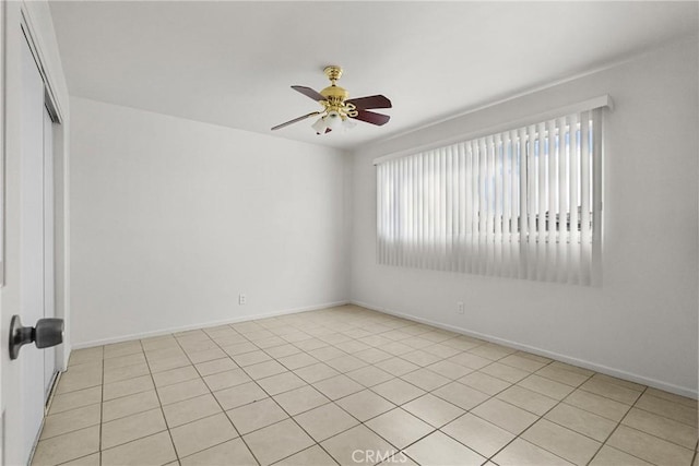 spare room with ceiling fan and baseboards