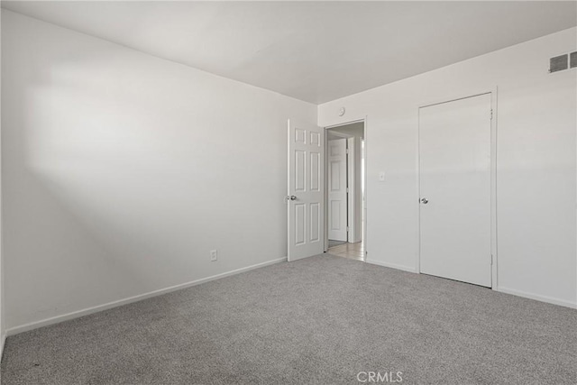 unfurnished bedroom with light carpet, baseboards, and visible vents