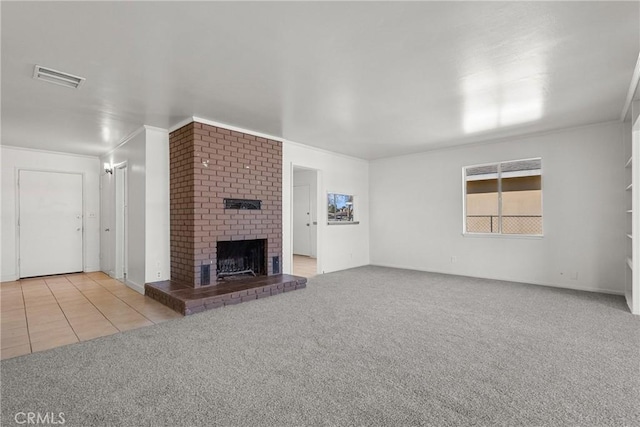 unfurnished living room with light carpet, a fireplace, visible vents, and light tile patterned floors