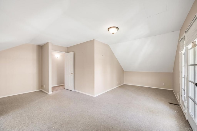 additional living space with baseboards, carpet, and lofted ceiling