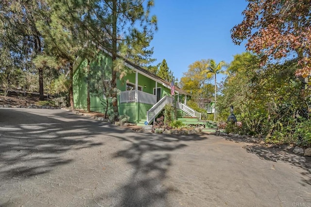 view of side of property featuring a porch and stairway