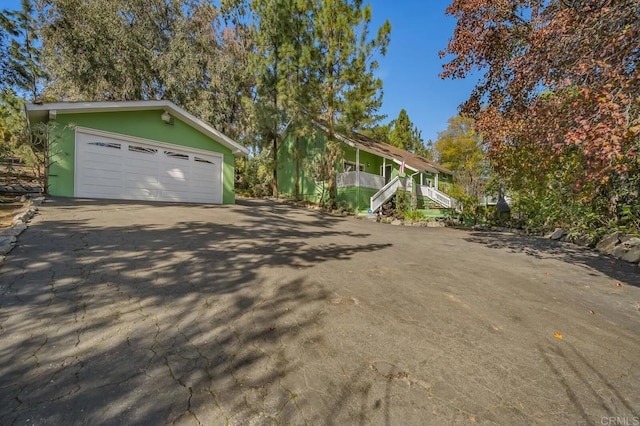 view of front facade featuring a garage, stucco siding, driveway, and stairway