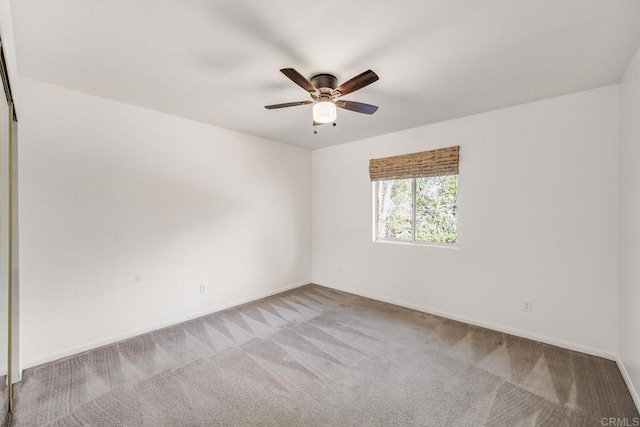 carpeted empty room with baseboards and a ceiling fan