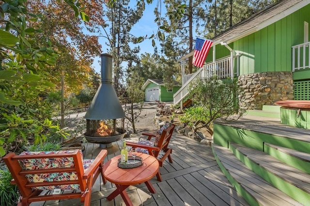 deck featuring an outdoor fire pit and stairway