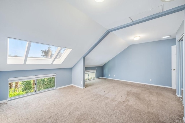 bonus room featuring vaulted ceiling with skylight, carpet flooring, and baseboards
