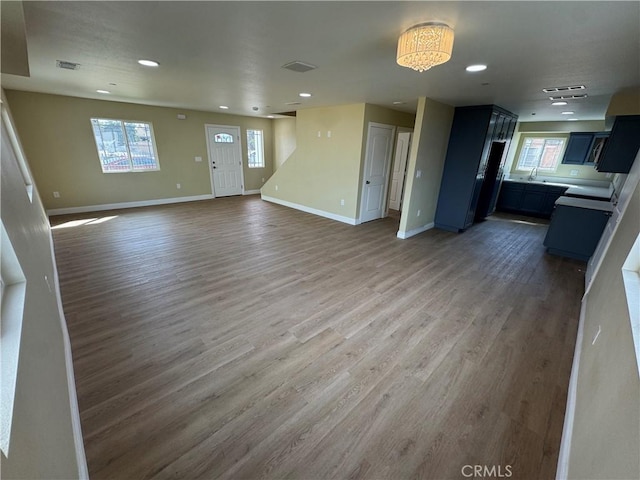 unfurnished living room featuring recessed lighting, visible vents, baseboards, and wood finished floors