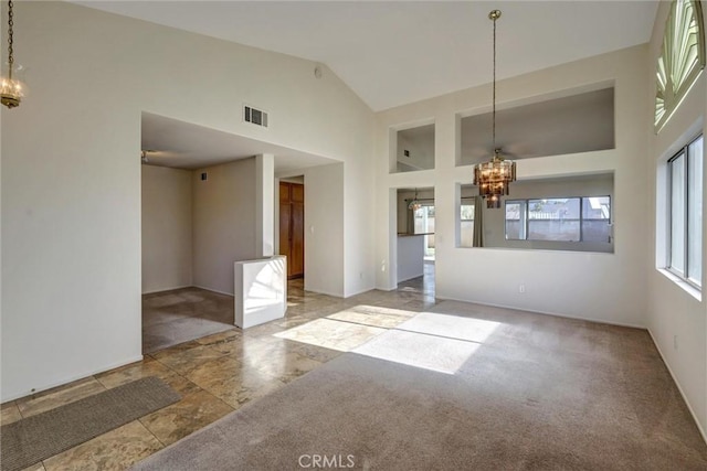 unfurnished room featuring carpet floors, an inviting chandelier, visible vents, and high vaulted ceiling