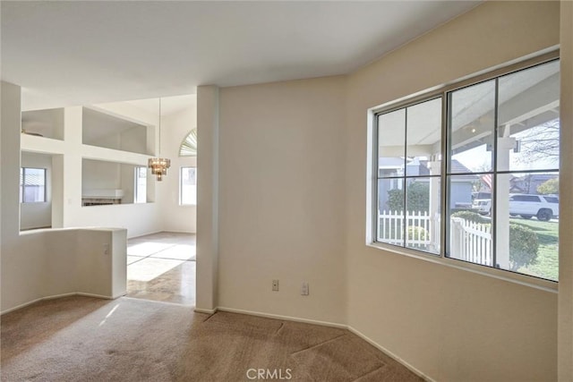 unfurnished room featuring light colored carpet and an inviting chandelier