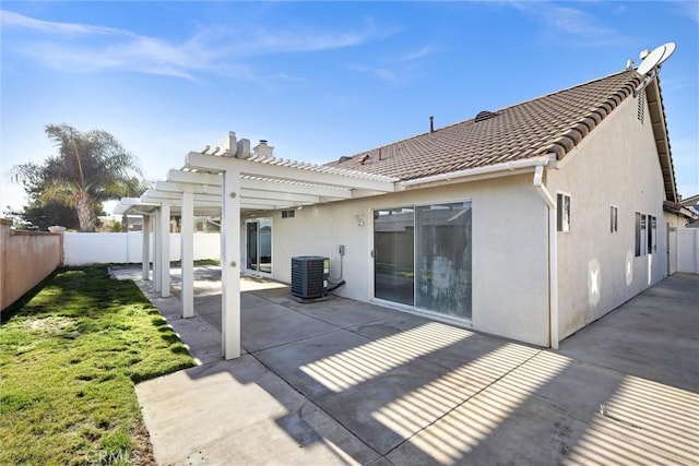 rear view of house featuring stucco siding, central air condition unit, a patio area, a pergola, and a fenced backyard