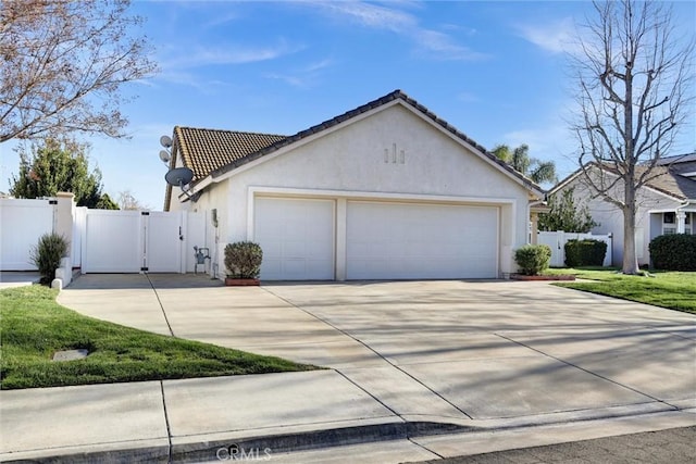 view of side of property with concrete driveway, a gate, and stucco siding