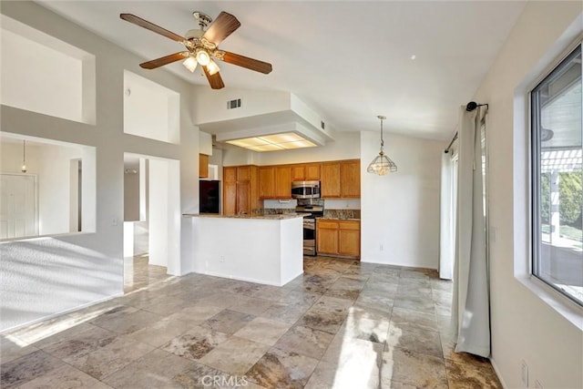 kitchen featuring decorative light fixtures, lofted ceiling, visible vents, appliances with stainless steel finishes, and brown cabinetry