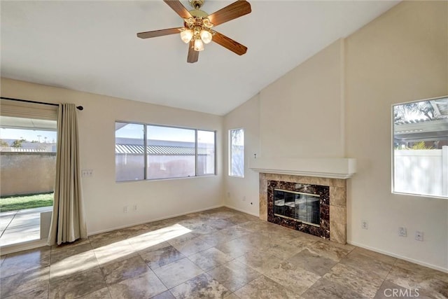 unfurnished living room with high vaulted ceiling, a premium fireplace, a ceiling fan, and baseboards