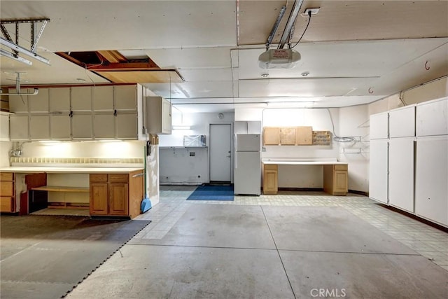 garage with freestanding refrigerator and a garage door opener