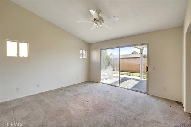 empty room with lofted ceiling, ceiling fan, and light colored carpet