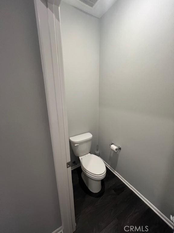 bathroom featuring wood finished floors, toilet, and baseboards