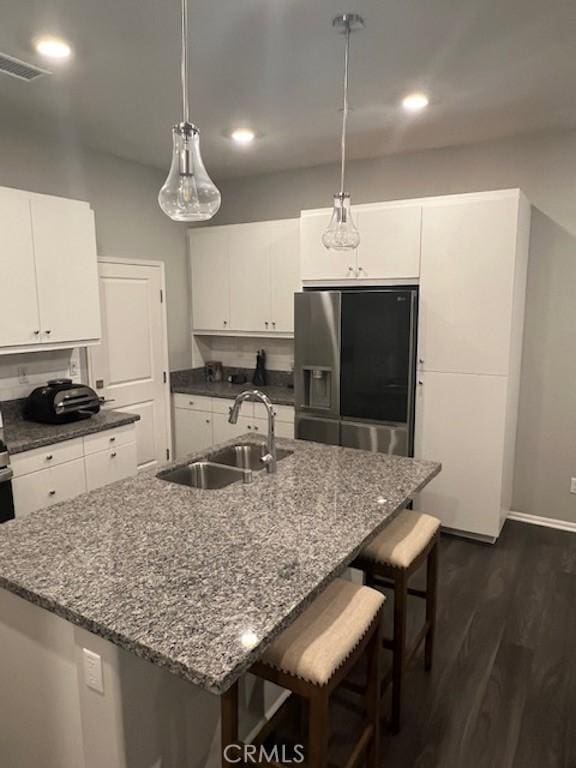 kitchen featuring pendant lighting, white cabinetry, a sink, and stainless steel refrigerator with ice dispenser