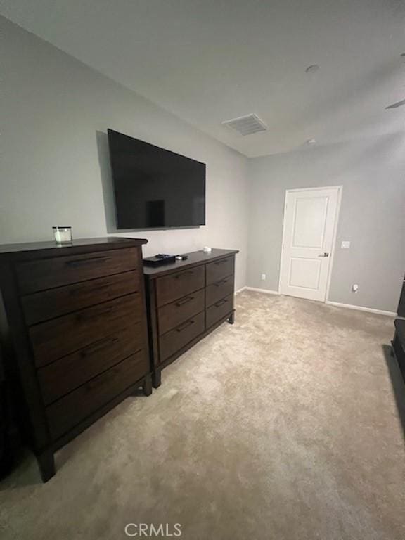 bedroom with light colored carpet and baseboards