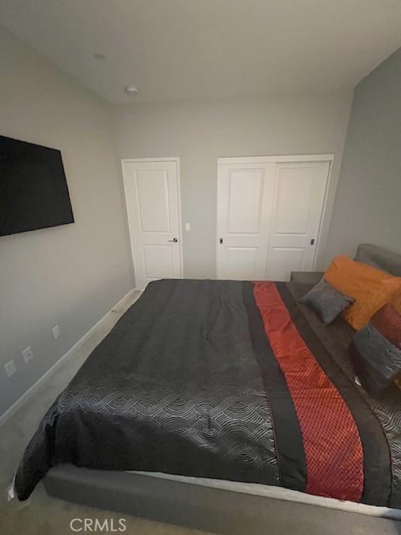 carpeted bedroom with baseboards and a closet