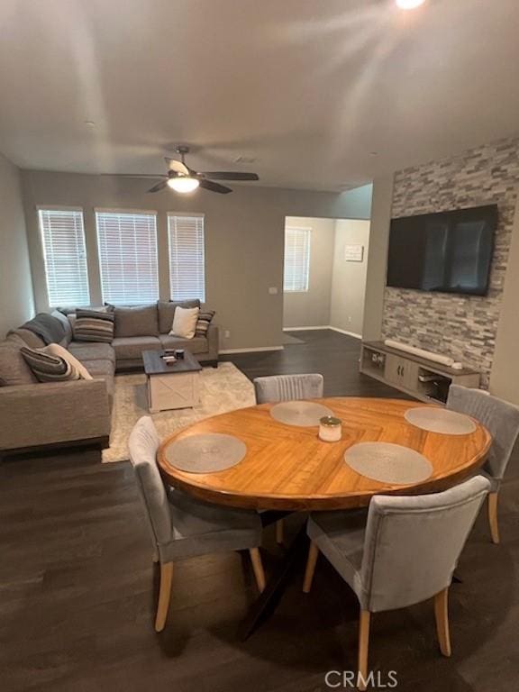 dining space featuring a ceiling fan, dark wood finished floors, and baseboards