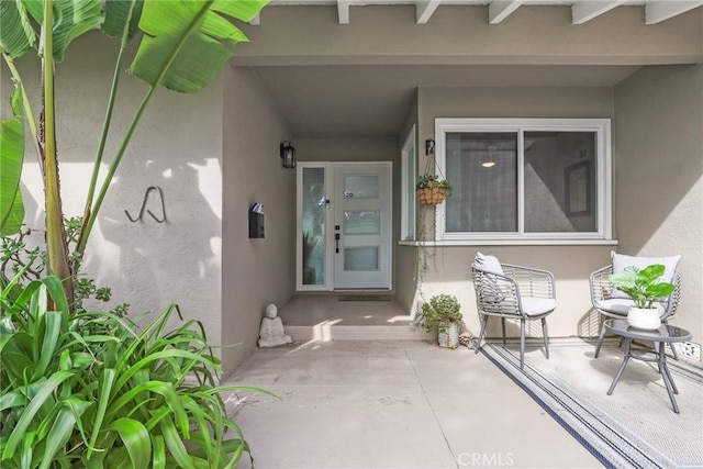 property entrance featuring a patio and stucco siding