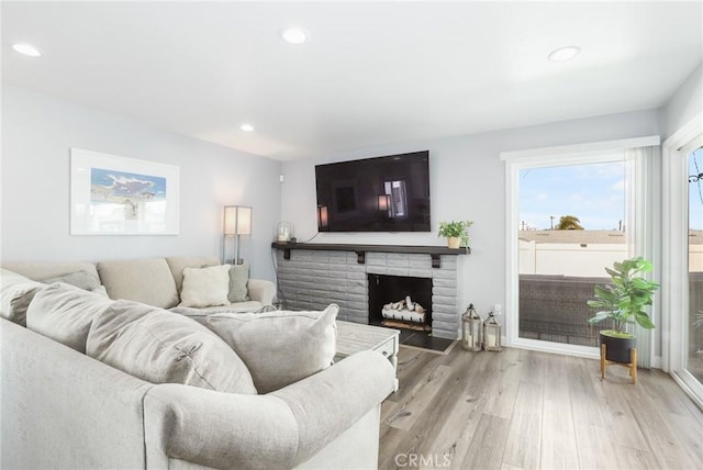 living room with light wood finished floors, a fireplace, and recessed lighting