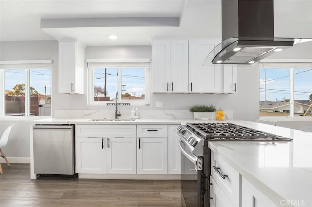 kitchen with dark wood-style flooring, island exhaust hood, stainless steel appliances, white cabinetry, and a sink