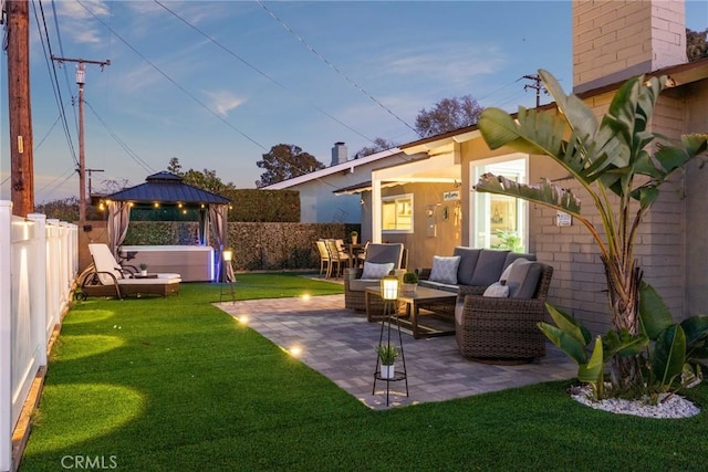 view of patio / terrace featuring a fenced backyard, outdoor lounge area, a hot tub, and a gazebo