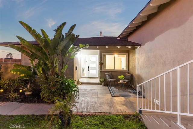 property entrance with a patio and stucco siding