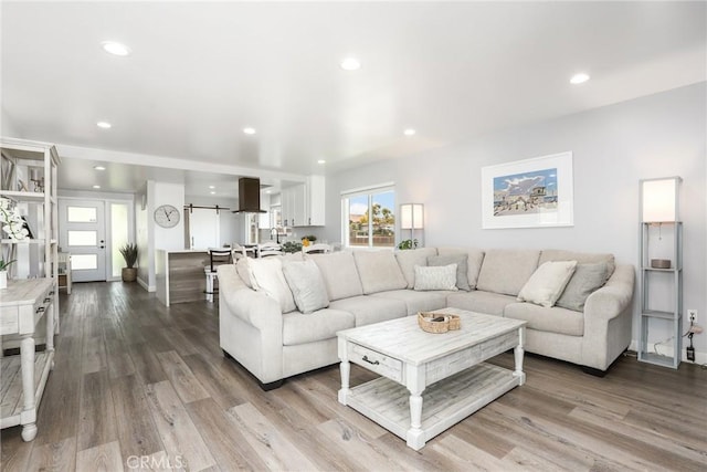 living room with baseboards, recessed lighting, and light wood-style floors