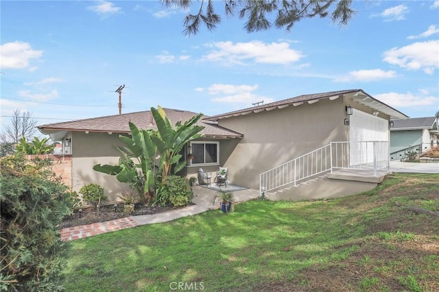 view of front of house featuring a front yard, concrete driveway, an attached garage, and stucco siding