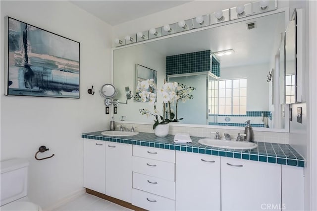 full bathroom featuring visible vents, a sink, toilet, and double vanity