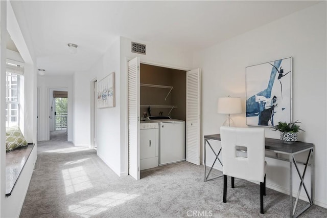 office featuring washing machine and dryer, visible vents, and light colored carpet